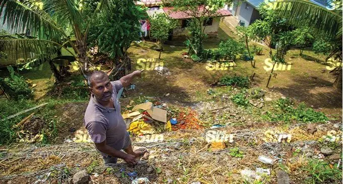 Vikash Chand points out the slope next to his home where a driver lost control of his vehicle carrying vegetables plummeting down the slope on November 1 2021.  Photo: Leon Lord