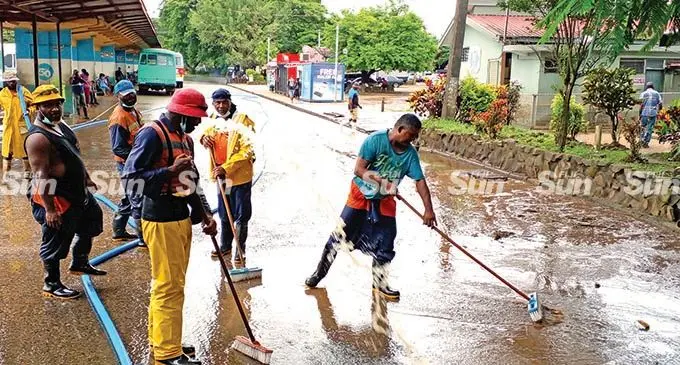 Ba Town Council workers clean the mud and silt at the bus stand area on February 9, 2022.  Photo: Salote Qalubau