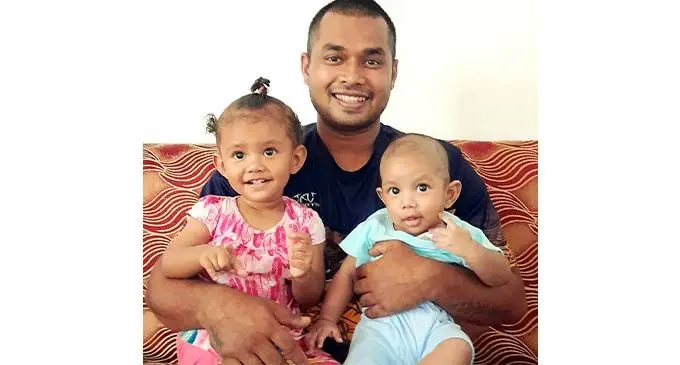 Police Constable Savenaca Joape holds his daughter (left) Grace Faith Vinakaidakuna and son Manasa Koroivere at his home in Lautoka on September 5, 2021.