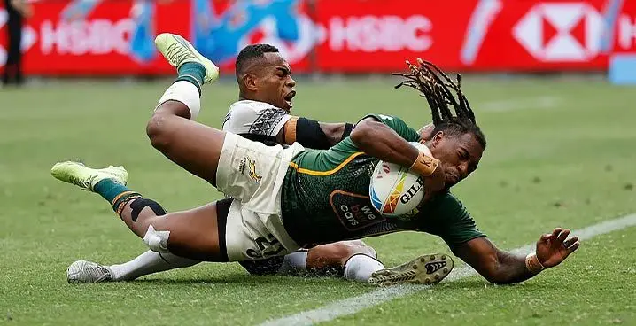 South Africa's Darren Adonis beats Fiji Airways Fijian men's rugby sevens winger Vuiaviwa Naduvalo to the ball to score a try in the Cup semifinal of the Sydney Sevens at the Allianz Stadium in Australia on January 29, 2023. South Africa won 31-12. Photo: World Rugby