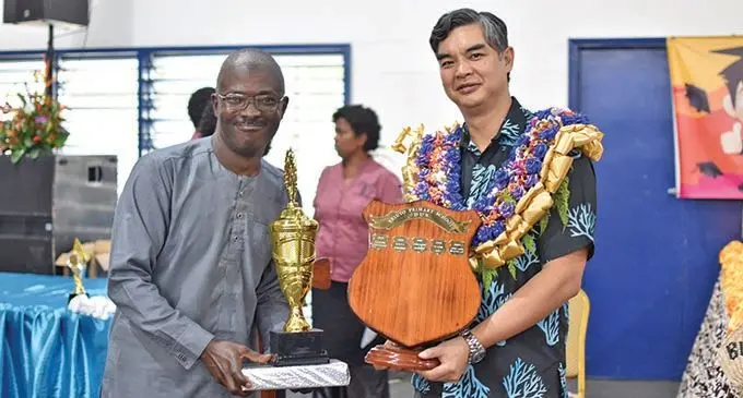 Tairu Afolarin (left)  receives the dux award on behalf of his daughter Haliyah on November 20, 2019, from the Ambassador and Head of the European Union (EU) Delegation for the Pacific, Sujiro Seam, during the Veiuto Primary School prizegiving ceremony at the FMF National Gymnasium in Suva.   Photo: Shreeya Verma 