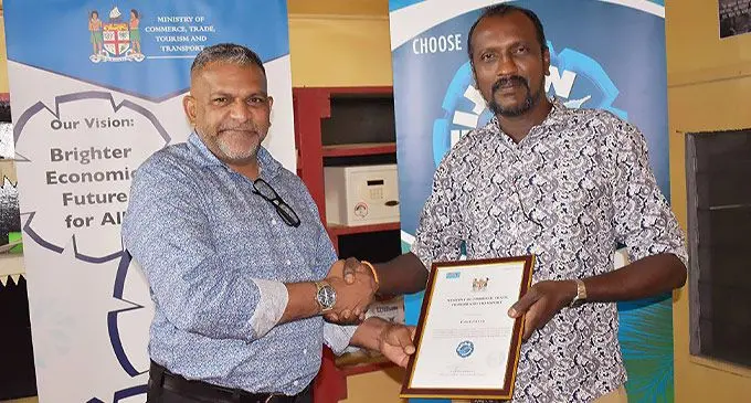 Minister for Commerce, Trade, Tourism and Transport Faiyaz Koya (left) hands over the Fijian Made-Buy Fijian certificate to FORCE Pte Limited staff Dinesh Ram in Savusavu on March 11, 2022.