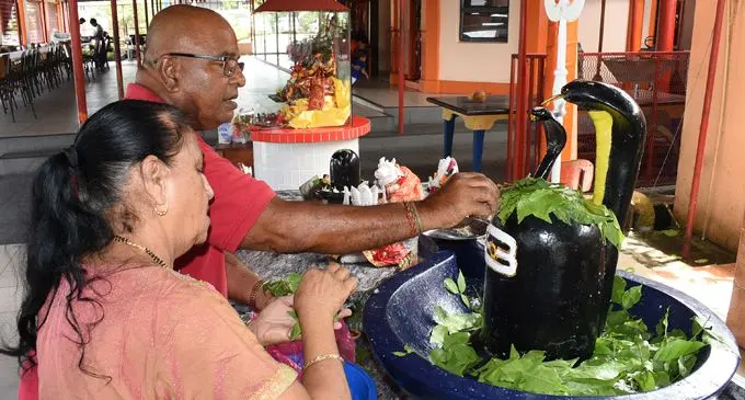 Hindu devotees Vincent Singh and Saroj Singh offer belpatra (Vilva leaf) to Lord Shiva (Shiv-ling or Shiv-lingam) as Hindus around the world celebrated Shivratri on February 14, 2018. Photo: Ronald Kumar