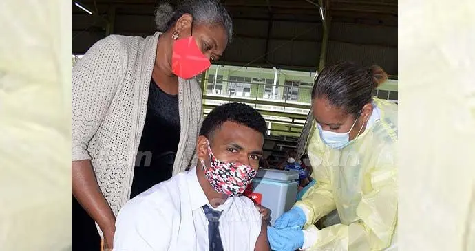 Year 12 student Saula Muriwaqa of Queen Victoria School with his mother, Milika Muriwaqa, as he receives his first dose of Moderna vaccine from Staff Nurse Merewalesi Baba at Gospel High School hall on September 20, 2021. Photo: Ronald Kumar