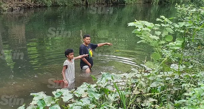 Losalini Veisa (right), and her niece, Esther Veisa by the spot in Tawatawa River where Michael Mau’s body was retrieved. Photo: Nicolette Chambers