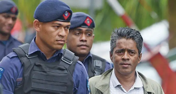 Kishore Kumar escorted by Police officers to Court house holding cell on November 27, 2020.  Photo: Ronald Kumar