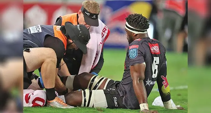 Sharks loose-forward and Springbok captain Siya Kolisi receiving treatment for his injured knee (left) during their United Rugby Championship clash with Munster at Kings Park in Durban on April 22, 2023. Right: Kolisi on his way out of the field. Photo: Gallo Images/ Steve Haag Sports