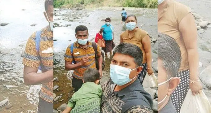 Jitendra Kumar holding his child with other teachers as they are about to cross the river on their way to Nayawa Settlement in the interior of Ra.