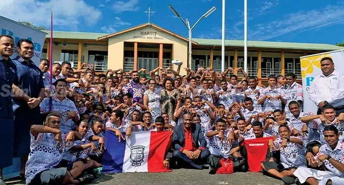 M for Marist...Marist Brothers High School acting head of school Asish Dayal and Bula Outsourcing chief executive officer and managing director Josie Prasad among the athletics team after their first Friday mass and sponsorship handover on August 5, 2022. Photo: Sereana Salalo