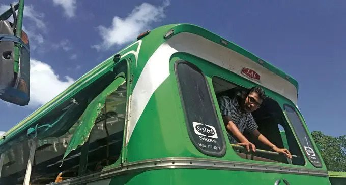 Nasese Buses Limited manager Nitesh Prasad shows the damage on the side panel and the missing rear sreen allegedly damaged by some students. Photo: Setilita Bolanavanua.