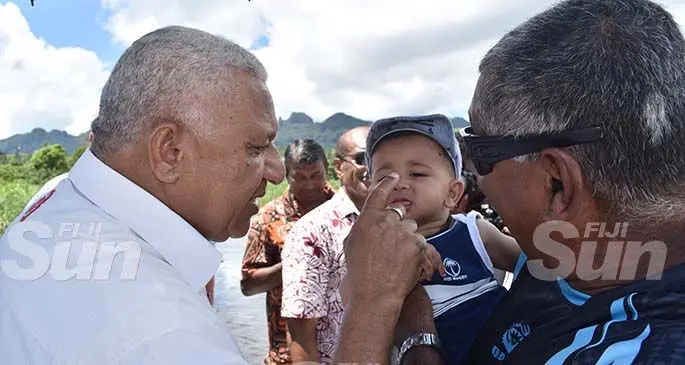 Prime Minister Voreqe Bainimarama (left) with Mohammed Zoraiz as he is carried by grandfather Abdul Nazim Ali at Korotari Crossing in Labasa on January 29,2020. Photo: Shratika Naidu