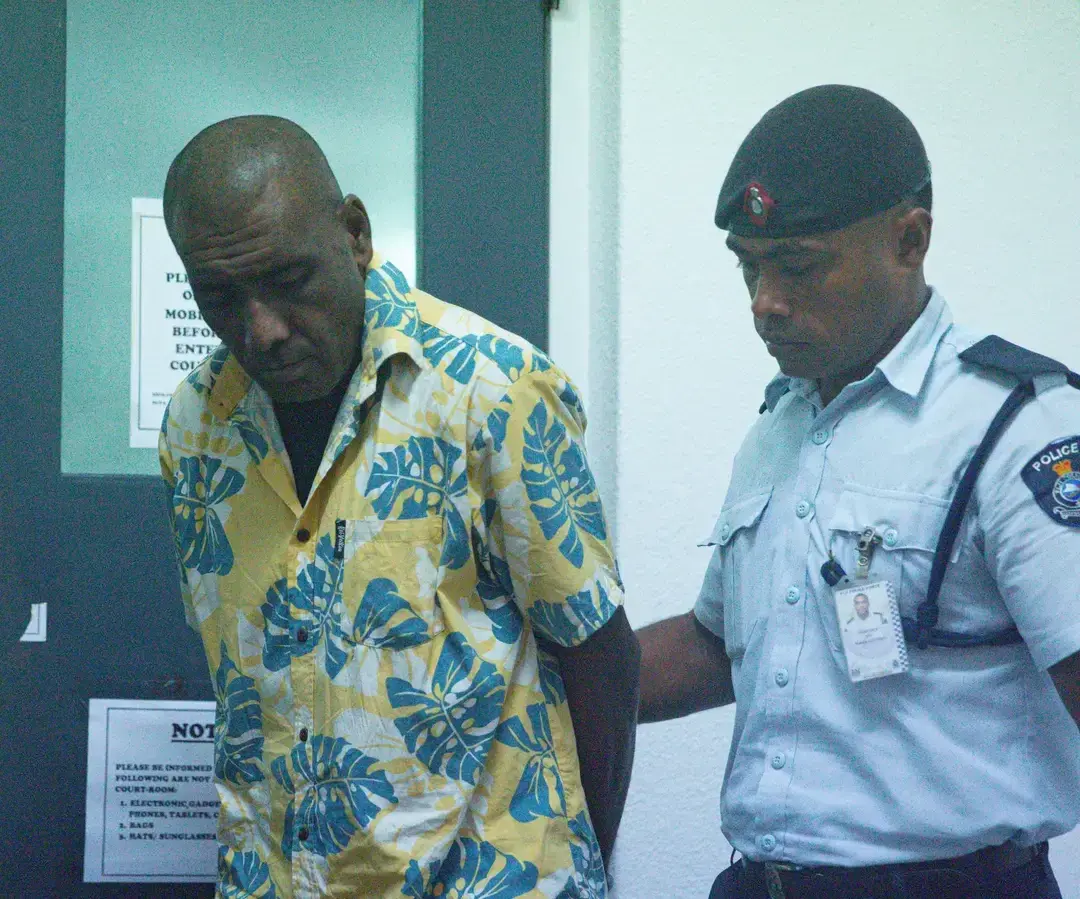 Murder accused Samuela Dasalusalu escorted by a police officer outside the High Court in Suva. 