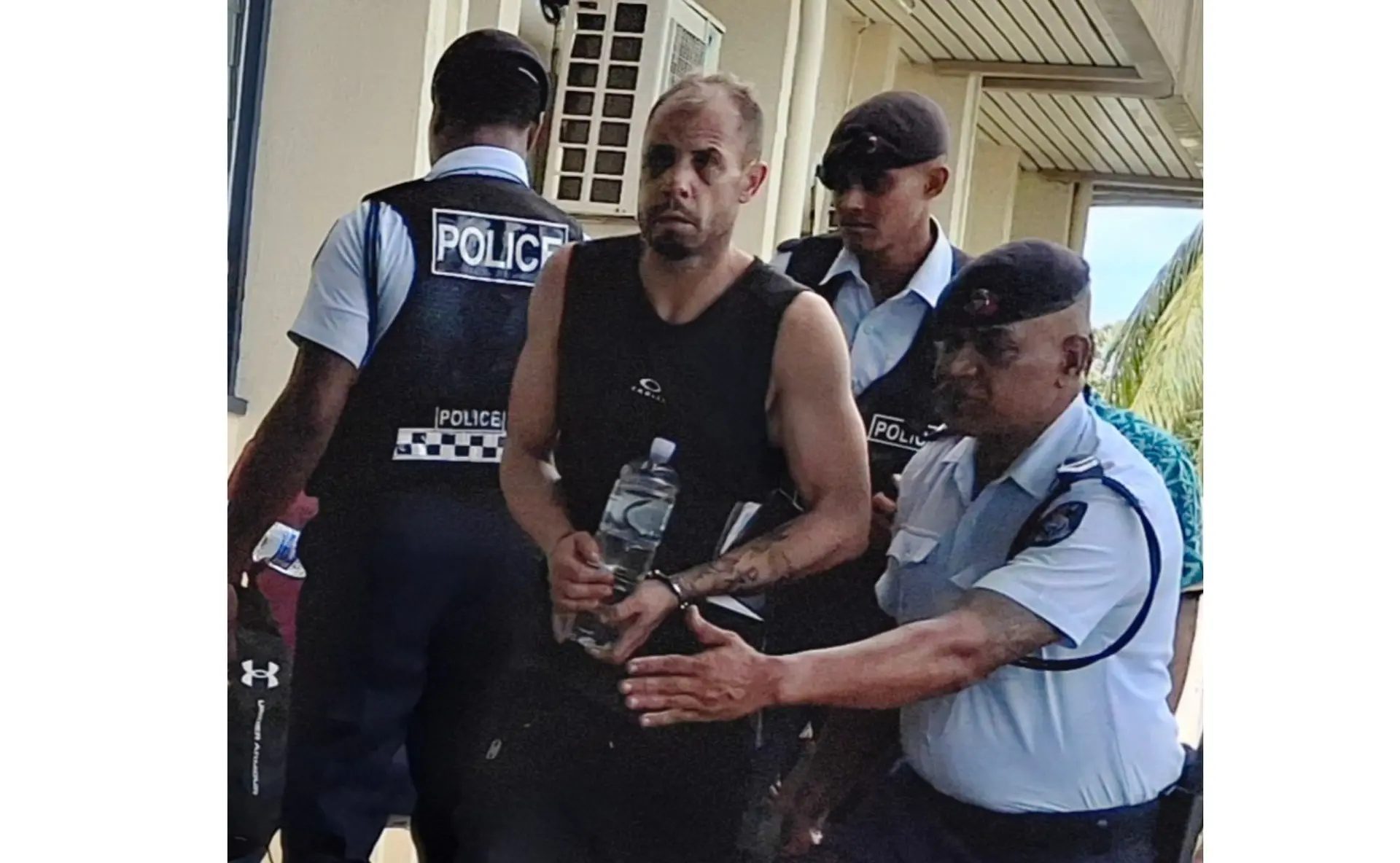 American Gregory Daniel Agajanian escorted by police officers at the Nadi Magistrate Court.