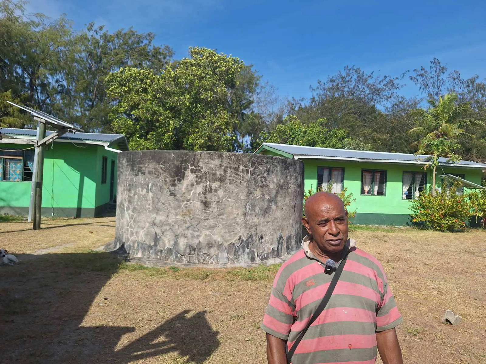 Yasawa-i-Rara elder Maikeli Momolevu stands infront of the tank that stores rainwater.
