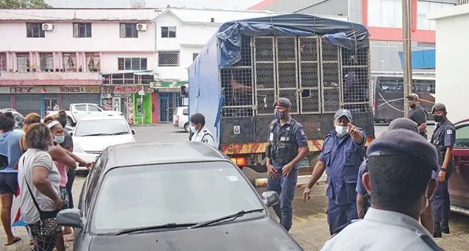 Officers from the Police Special Response Unit behind a truck loaded with people taken into custody following brawl in Nabua on October 4, 2021.  Photo: Ronald Kumar.