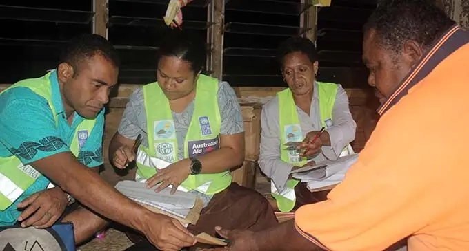 ADRA Fiji and ITAB staff distribute cash to recipients in Kadavu.