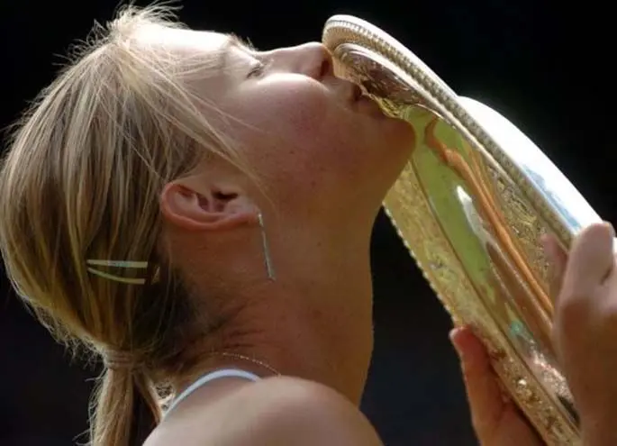 Maria Sharapova kisses the trophy after winning her first major title at Wimbledon on July 3, 2004. (Xinhua/Cheng Min)