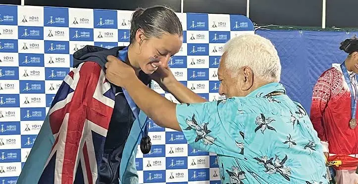 Fiji swimmer Anahira McCutcheon receives her silver medal from Oceania National Olympic Committees president Dr Robin Mitchell at the Solomon Islands National Aquatic Centre in Honiara on November 21, 2023 Photo: Serana Salalo
