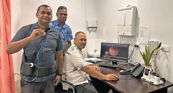 Patient (front) with Clinical Director Dr. Sanson Fousaga (sitting) and PSH Research and Development Team Head Solomone Suguta. Photo: Pacific Specialists Healthcare