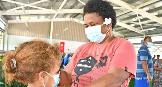 Nakasi Market vendor Sisilia Saidova assists Lorine Morrell with her mask at the Nakasi Market on February 27, 2025. Photo: Ronald Kumar