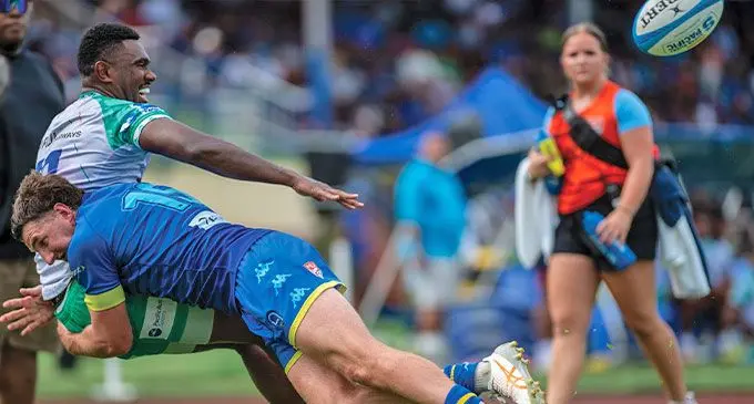 Swire Shipping Fijian Drua utility back Vuate Karawalevu offloads as he is tackled by a Los Angeles Rugby Football club player during their pre-season match at Churchill Park, Lautoka on January 24 2024. Photo: Leon Lord