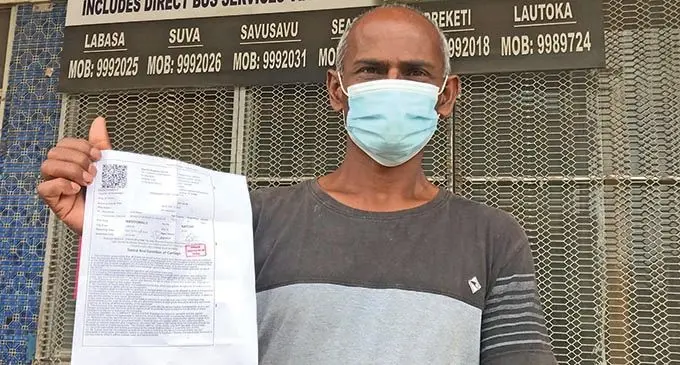HEADING BACK HOME... Yogendra Prasad showing off his boat ticket in front of Interlink  Shipping Line Limited Office in Labasa on June 2, 2021. He is originally from Korowiri, Labasa, and travelled to the North to carry out maintenance work at his house. He is happy to return to Newtown, Nasinu, where his wife and daughter-in-law await him. The 50-year-old has a son in Rakiraki. Reporting time is 9pm tomorrow.  Photo: Shratika Naidu