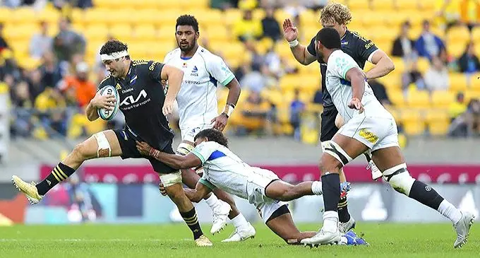 Hurricanes No.8 Tyler Laubscher (with ball) tries to break away from Simione Kuruvoli’s tackle as Isoa Nasilasila and Meli Derenalagi close in at the Sky Stadium, Wellington on May 8, 2022. Photo: Stuff