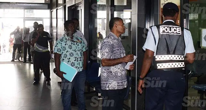 A Police officer organising people to practise social distancing as they wait in line outside the Land Transport Authority office at Downtown Boulevard in Suva on May 5, 2020. Photo: Ronald Kumar