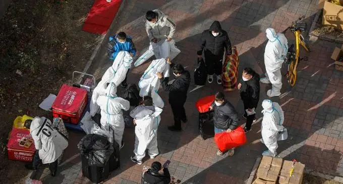 Volunteer health workers wear protective clothing outside a building with a confirmed case in Beijing, China.