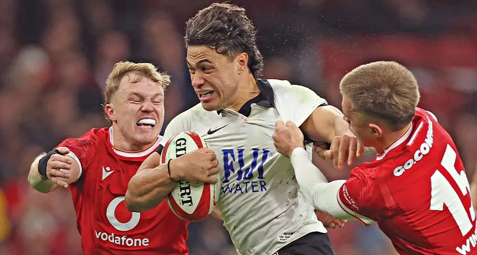 FIJI Water Flying Fijians fly-half Caleb Muntz runs in to score a try as he is tackled by Wales' wing Blair Murray (Left) and full-back Cameron Winnett (right) during their Autumn Nations Series International test match at the Principality Stadium, in Cardiff on November 10, 2024. Fiji won 24-19. Photo: AFP 