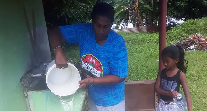 From left: Shakuntala Mani with her grand daughter Kiarra Kishor storing water into empty bottles and buckets at her home in  Sulua Street, Lautoka.  Photo: Rohit Kumar