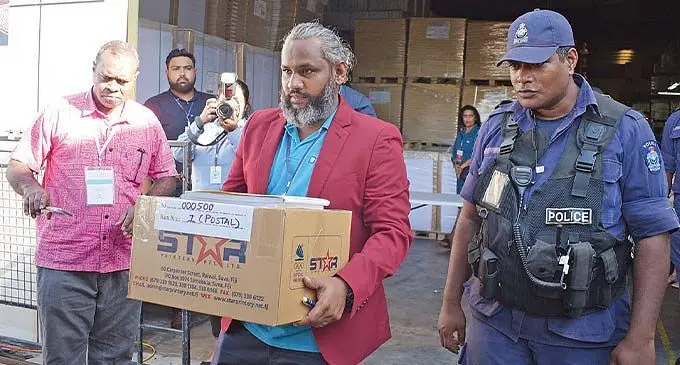 Fijian Election office official, Daniel Niraj, with assistance from Police officer escort the first 2022 General Election postal ballot papers from the printing press to an FEO secure facility in Lauacala Beach on November 17, 2022. Photo: Ronald Kumar