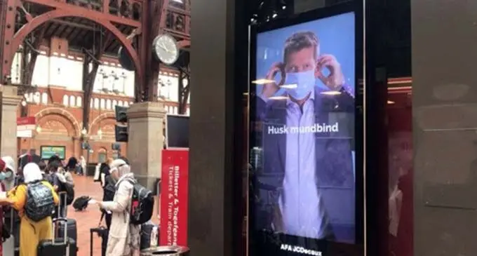 An information screen in the Central Station of Copenhagen shows Danish health authorities' promotions on wearing face-masks on public transports in Copenhagen, Denmark, Aug. 24, 2020. (Photo by Anders Kongshaug/Xinhua)