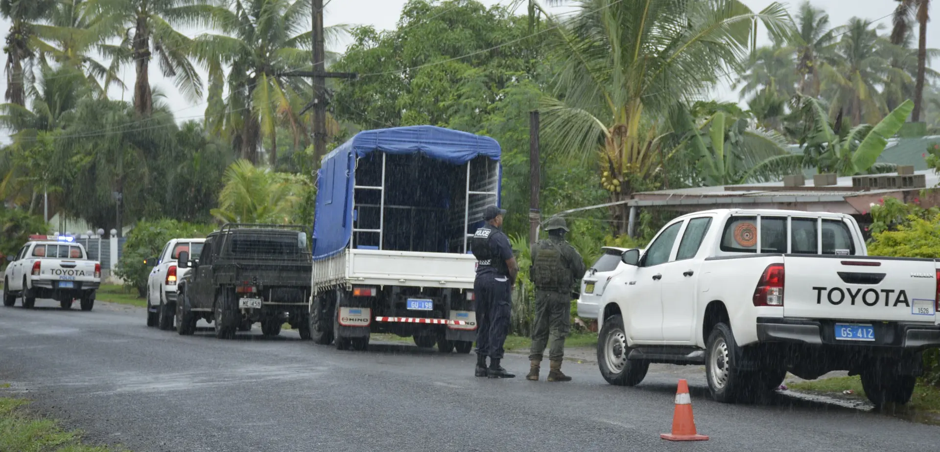 Seven vehicles were parked along the roadside, restricting motorists to one lane as rain drizzled over the area.