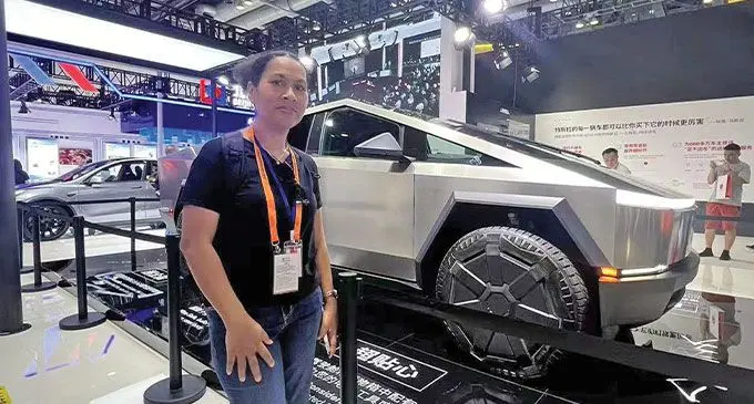 Tabutei Prasad with an electric car on display at the Trade showcase.