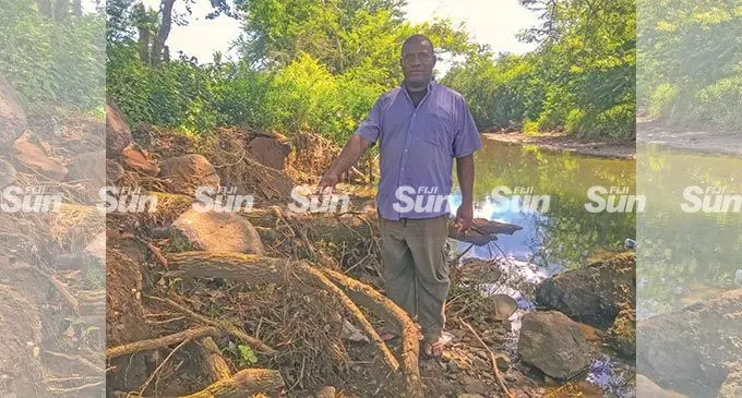 Taivesi Nawaqa of Drauniivi village in Ra points to the tree roots that are now exposed due to the riverbank soil erosion caused by the rise in sea level. Photo: Kelera Sovasiga- Tuisawau