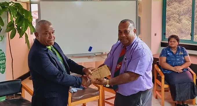 Minister for Fisheries and Forestry, Kalaveti Ravu, presents the cash grant to the landowner and church minister of Nayarabale Village in Vaturova, Cakaudrove province recently. Photo: Sampras Anand