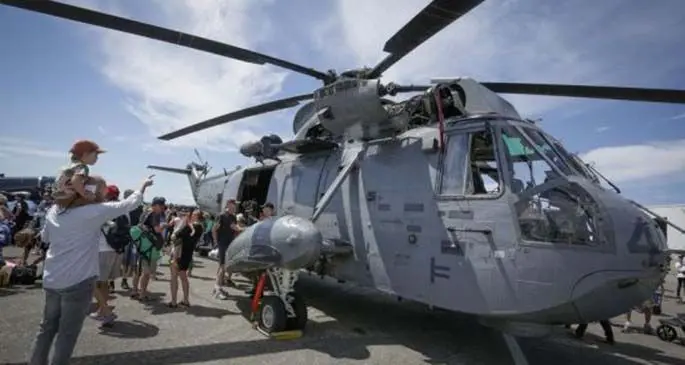People look at a helicopter from Canadian airforce at the annual Boundary Bay Airshow in Delta, Canada, July 21, 2018. (Xinhua/Liang Sen)