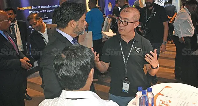 Alibaba Cloud Fiji account director, Andy Shi with the Attorney-General and Minister for Economy, Aiyaz Sayed-Khaiyum (middle) alongside Datec senior software consultant, Prithi Kumar during the exhibition at the Fiji Tech Summit 2022 at the Intercontinental Fiji Golf Resort and Spa in Natadola on November 3, 2022. Inset: Attendees at the summit. Photo: Nicolette Chambers
