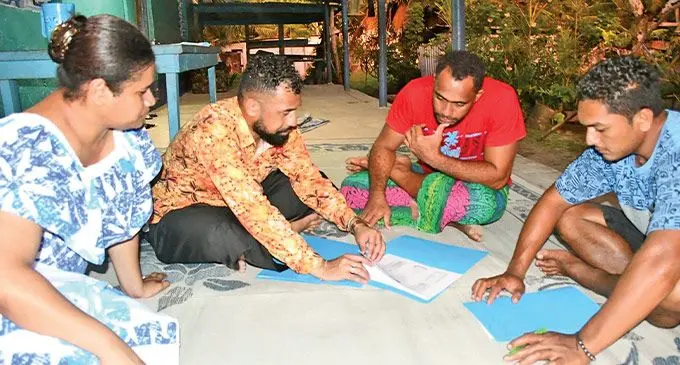 Social welfare workers briefing two community members about policing