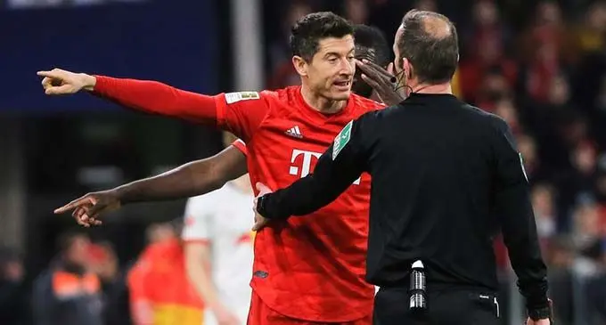 Robert Lewandowski (L) of Bayern Munich complains to the referee during a German Bundesliga football match between FC Bayern Munich and RB Leipzig in Munich, Germany, Feb. 9, 2020. (Photo by Philippe Ruiz/Xinhua)