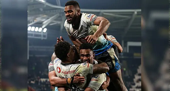 Vodafone Fijian Bati captain Kevin Naiqama (4) celebrates one of his two tries with Vuate Karawalevu (facing camera) and Sunia Turuva during their quarterfinal clash against New Zealand at the Rugby League World Cup at MKM Stadium, Hull, England on November 6, 2022. Photo: NRL.com