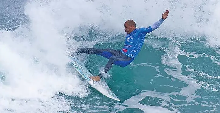 A man enjoys surfing in his Rip Curl outfit. 