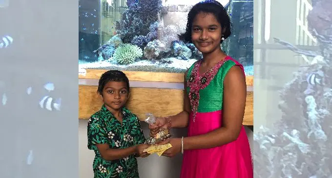 Aahil Muhammed hands over his savings to Shaiba Nuraiya Faradth at the International School Suva on April 24, 2019.  Photo: Neelam Prasad
