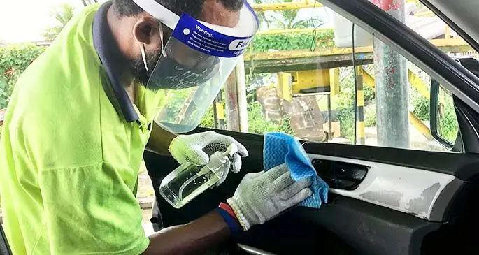Senitiki Waqanisau disinfecting vehicle at Clean Source Steam Carwash. 