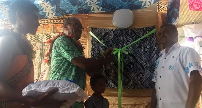 Minister for Infrastructure, Transport, Disaster Management and Meterological Service Jone Usamate cuts the ribbon to celebrate the electrification of Dreketi.