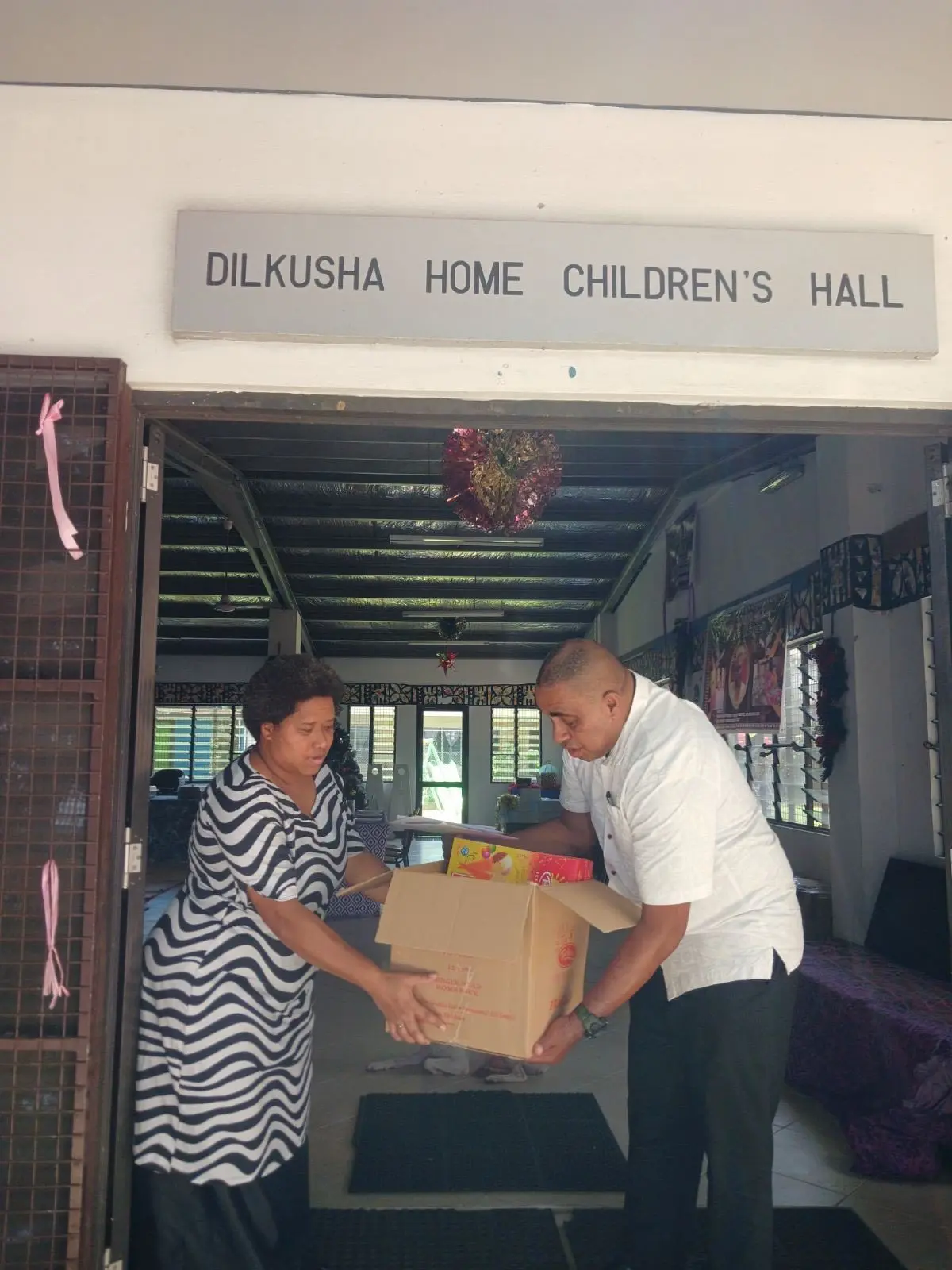A caregiver and deaconess at the Dilkusha Home receives Christmas gifts from Prime Minister Sitiveni Rabuka’s security detail during their visit to the home in Nausori on December 25, 2025.