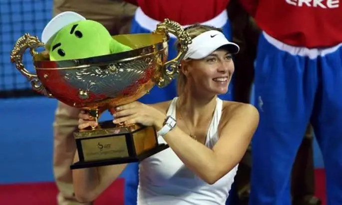 Maria Sharapova of Russia holds up the trophy after beating Petra Kvitova of the Czech Republic to win the China Open tennis tournament in Beijing Oct. 5, 2014. (Xinhua/Guo Yong)