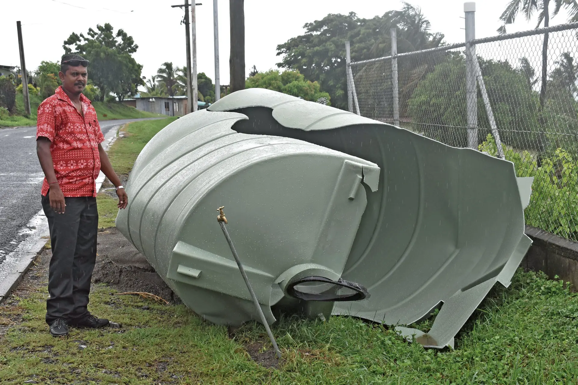 Avinesh Kumar, with a damaged water tank found damaged along the road side in Field 40 in Lautoka yesterday. Photo: WAISEA NASOKIA
