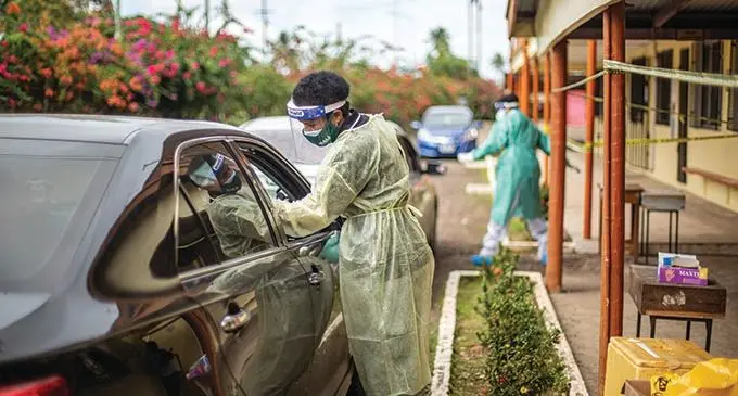 Swab on the go...Medical personnel, Joana Veikoso, conducts a swab for at the swab drive through centre at Vunimono High School in Nausori on July 14 2021.  Photo: Leon Lord